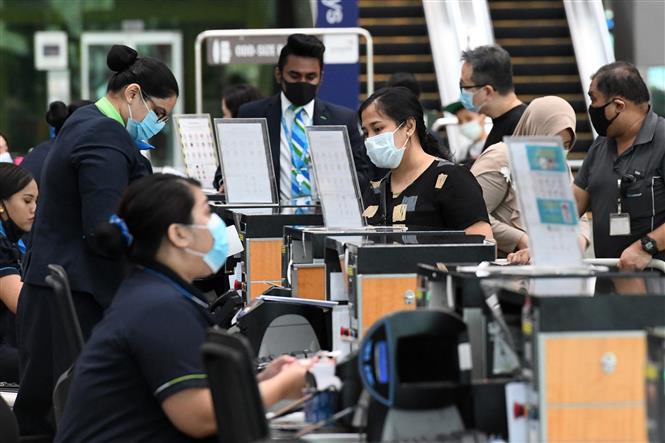 Hành khách làm thủ tục tại sân bay quốc tế Changi ở Singapore ngày 8/6/2020. Ảnh: AFP/TTXVN