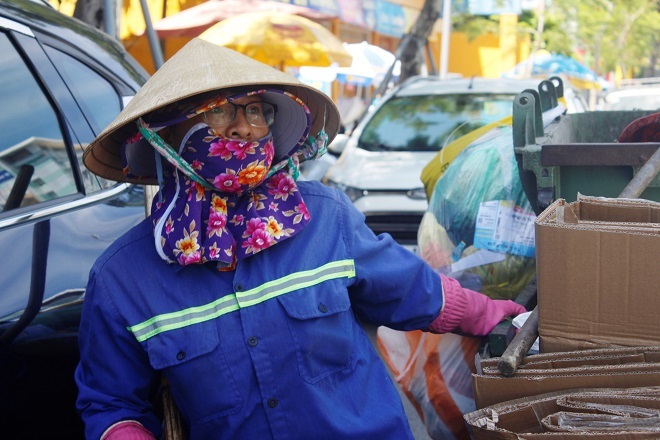 A female sanitation worker doing her job in hot weather