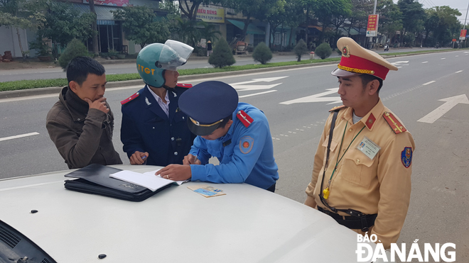 Lực lượng chức năng tiến hành xử phạt xe chạy chui tuyến Đà Nẵng - Thừa Thiên Huế.       		                    Ảnh: PHƯƠNG UYÊN