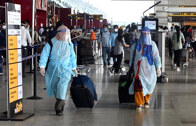  Hành khách đeo khẩu trang và mặc quần áo bảo hộ phòng lây nhiễm COVID-19 tại sân bay quốc tế Indira Gandhi ở New Delhi, Ấn Độ, ngày 25/5/2020. Ảnh: THX/ TTXVN