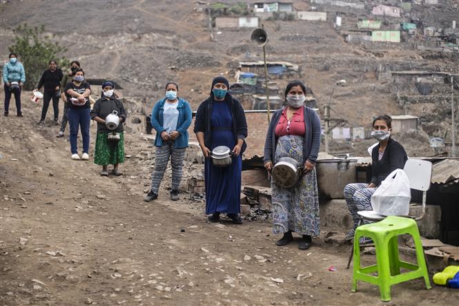  Người dân gặp khó khăn do ảnh hưởng của dịch COVID-19 xếp hàng chờ nhận lương thực cứu trợ ở ngoại ô thủ đô Lima, Peru ngày 28/5/2020. Ảnh: AFP/TTXVN