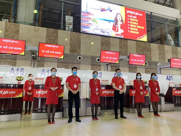Staff of Vietjet stand in front of its check-in counters (Photo: VNA)  