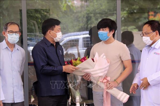 Lao Minister of Health Bounkong Syhavong (second from left) presents a flower bouquet to the last COVID-19 patient to leave the hospital in Laos (Photo: VNA)