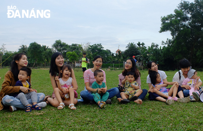 Chị Trần Thị Thanh Huyền (áo kẻ sọc ngang ngồi ở giữa) tham gia cùng các con trong một buổi học ngoại khóa ở công viên do chị tổ chức. Ảnh: Đ.H.L