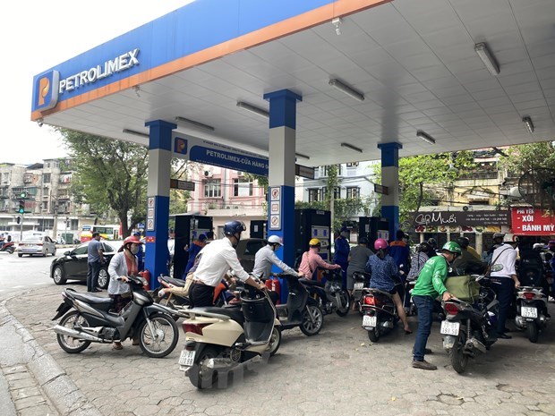Motorcyclists wait to have their vehicles refilled at a Petrolimex gas station (Photo: VNA)