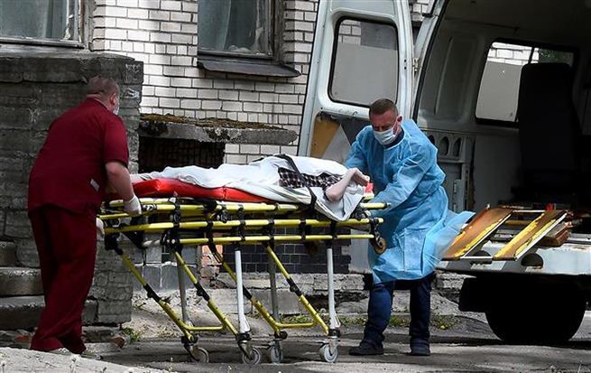  Nhân viên y tế chuyển bệnh nhân nghi mắc Covid-19 từ xe cứu thương vào một bệnh viện ở Saint Petersburg, Nga ngày 3-6-2020. Ảnh: AFP/TTXVN