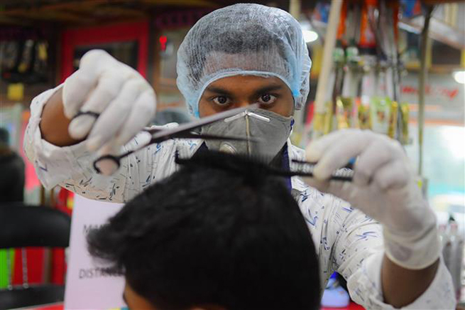  Đeo khẩu trang phòng Covid-19 tại một cửa hàng cắt tóc ở Agartala, Tripura, Ấn Độ, ngày 11-6-2020. Ảnh: THX/TTXVN