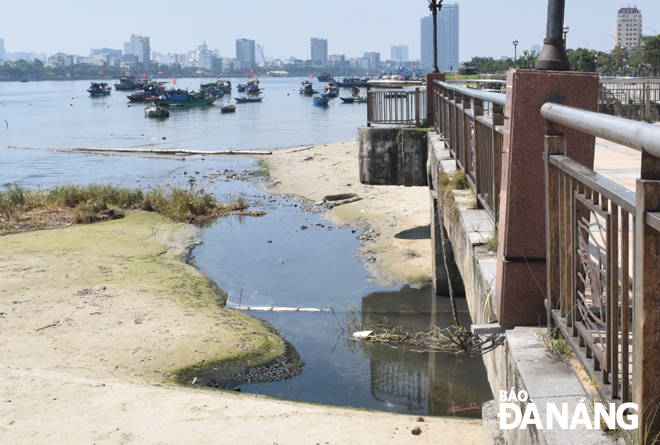 Nước thải tràn ra sông Hàn hằng ngày ở cửa xả hạ lưu trạm bơm Thuận Phước.  Ảnh: HOÀNG HIỆP