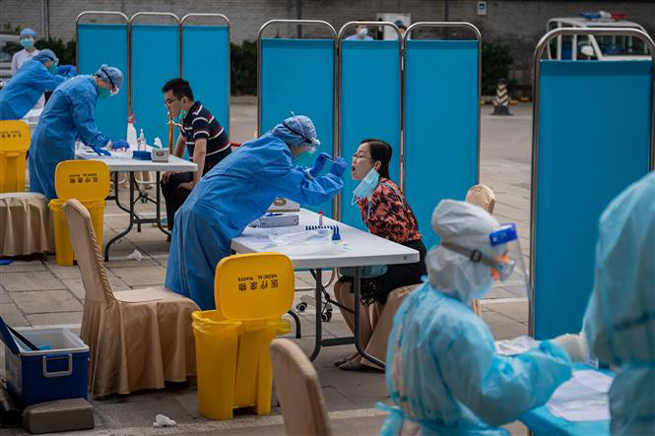   Nhân viên y tế lấy mẫu xét nghiệm Covid-19 cho người dân tại Bắc Kinh, Trung Quốc ngày 28-5-2020. Ảnh: AFP/TTXVN