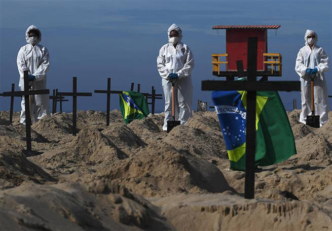  Nhóm tình nguyện đào huyệt mộ giả trên bãi biển Copacabana,để tưởng nhớ những người đã tử vong vì dịch bệnh viêm đường hô hấp cấp Covid-19 tại Rio de Janeiro, Brazil, ngày 11-6-2020. Ảnh: AFP/TTXVN