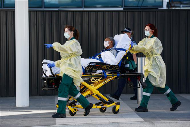   Chuyển bệnh nhân nhiễm Covid-19 tới bệnh viện ở Adelaide, Australia, ngày 21-4-2020. Ảnh: AFP/TTXVN