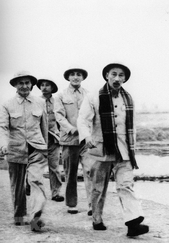  Phóng viên Võ Thế Ái của Việt Nam Thông tấn xã (đi sau Bác Hồ) tháp tùng Bác đi thăm công trình đập Thác Huống, Thái Nguyên, để viết tin, bài, tháng 12-1954. (Ảnh: Tư liệu TTXVN)