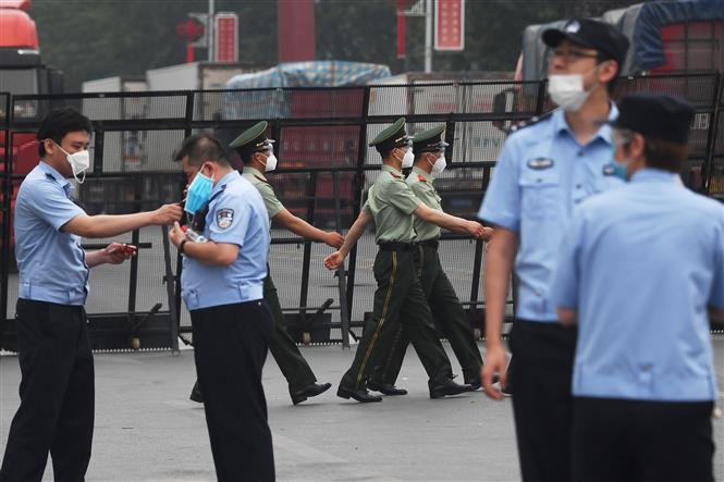 Cảnh sát gác tại lối vào chợ Tân Phát Địa ở Bắc Kinh, Trung Quốc, ngày 13-6, sau khi chợ phải đóng cửa do phát hiện ca nhiễm Covid-19 mới. Ảnh: AFP-TTXVN