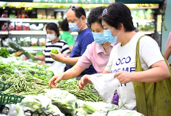  Người dân đeo khẩu trang phòng lây nhiễm COVID-19 khi mua hàng trong siêu thị ở Bắc Kinh, Trung Quốc, ngày 15/6/2020. Ảnh: THX/ TTXVN