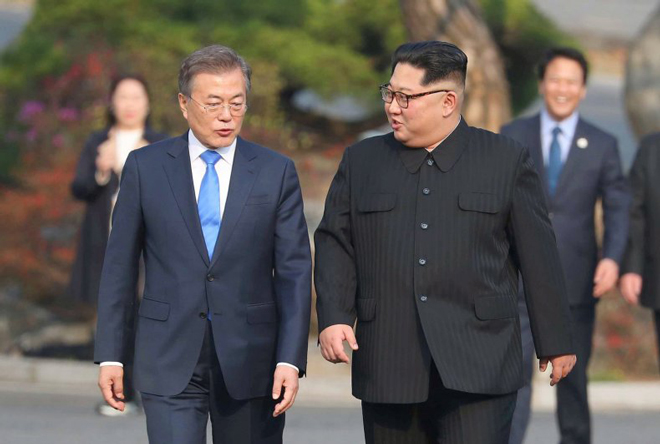 Tổng thống Hàn Quốc Moon Jae-in (trái) gặp gỡ nhà lãnh đạo Triều Tiên Kim Jong-un tại làng đình chiến Panmunjom, biên giới hai miền, vào ngày 27-4-2018. Ảnh: AP - 0.05 MB 	