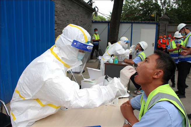  Nhân viên y tế lấy mẫu dịch xét nghiệm Covid-19 cho người dân tại Bắc Kinh, Trung Quốc ngày 17-6. Ảnh: THX/TTXVN