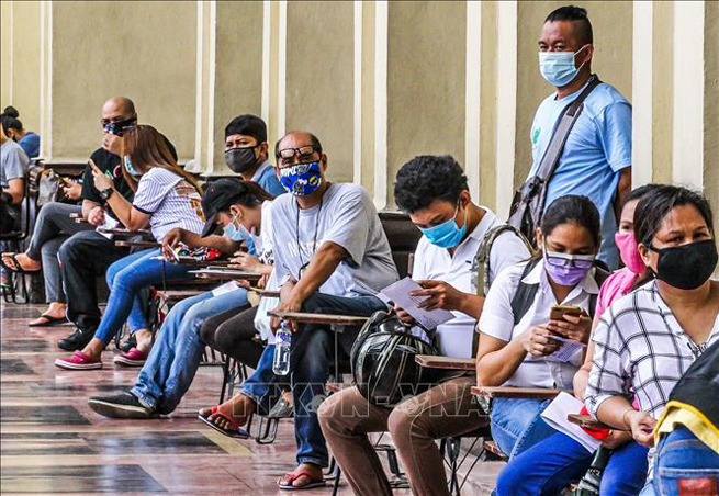 Người dân đeo khẩu trang phòng lây nhiễm Covid-19 khi xếp hàng bên ngoài bưu điện ở Manila, Philippines ngày 10-6. Ảnh: THX/TTXVN