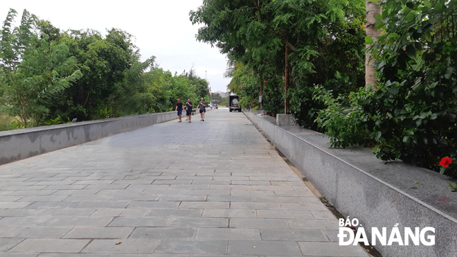 Beach-goers walking on a public footpath on the northern side of the Song - Danang Beach Villas project