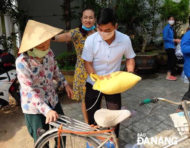 Cán bộ phường Hòa Khánh Nam trao quà hỗ trợ người dân ở khu vực bãi rác Khánh Sơn. Ảnh: PHƯƠNG CHI
