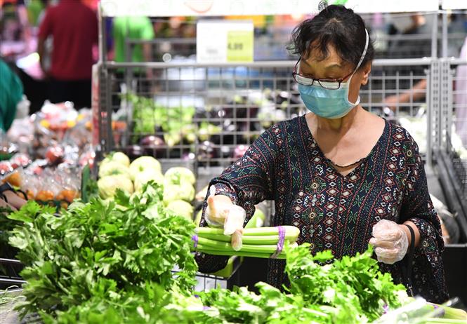  Người dân đeo khẩu trang phòng lây nhiễm COVID-19 khi mua thực phẩm tại siêu thị ở Bắc Kinh, Trung Quốc ngày 14/6/2020. Ảnh: THX/ TTXVN
