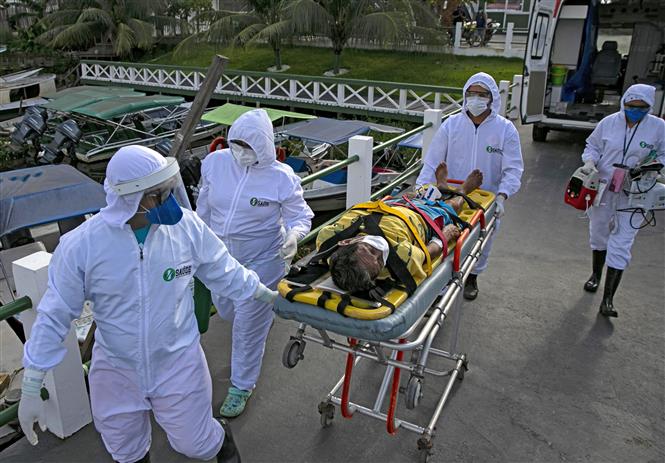  Nhân viên y tế chuyển bệnh nhân mắc COVID-19 tới bệnh viện ở Breves, Brazil. Ảnh: AFP/TTXVN