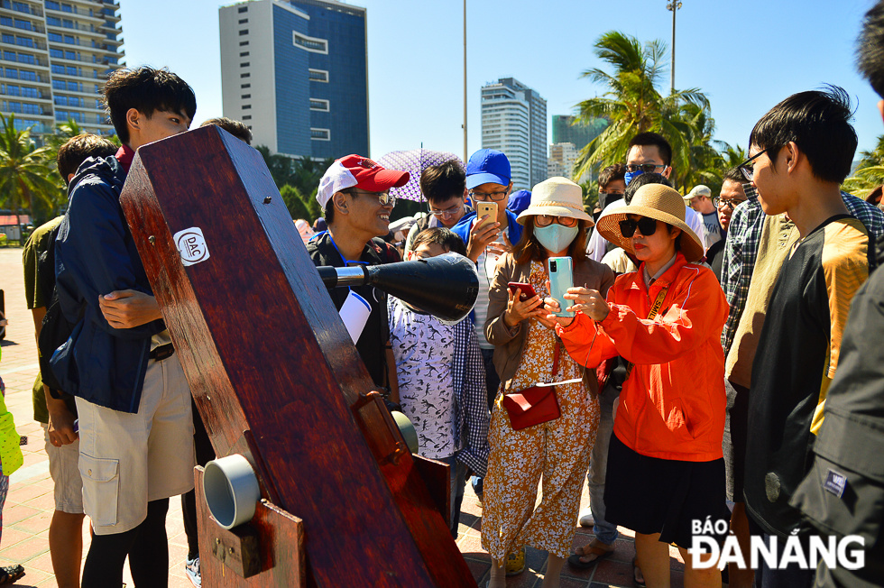 People watching an annular eclipse image on a reflecting telescope