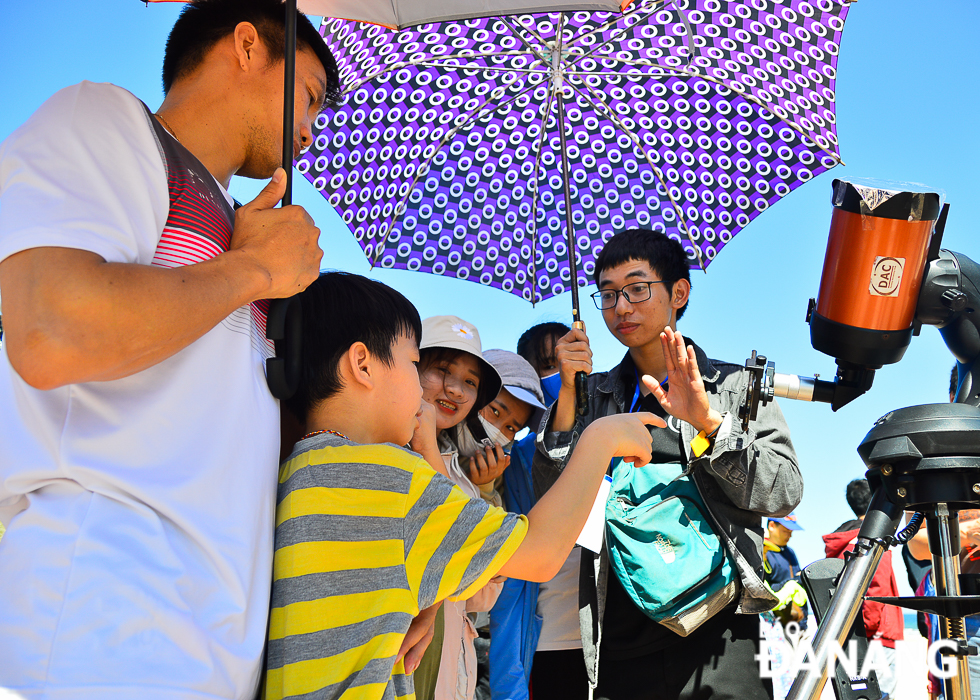 Nguyen Nhat Cuong (right), a member of the Da Nang Astronomy Club, explaining the annular eclipse for participants