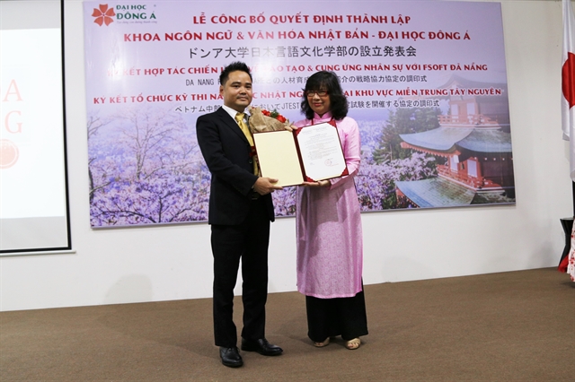 Head of Japanese language studies and culture research faculty Ngô Quang Vinh (left) receives the establishment decision from Đông Á College in Đà NẴng City. — VNS Photo Phương Chi