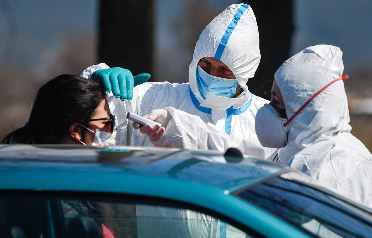 Nhân viên y tế kiểm tra thân nhiệt người dân nhằm ngăn dịch Covid-19 lây lan tại trạm kiểm tra ở khu nghỉ dưỡng Bansko, Bulgaria ngày 18-3-2020. (Nguồn: AFP-TTXVN)