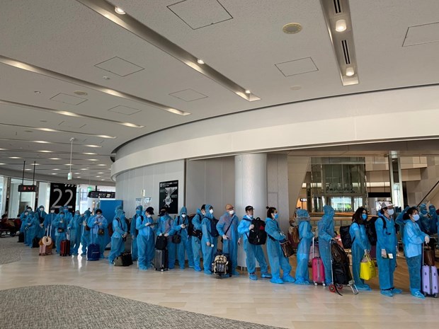 Repatriated Vietnamese citizens queuing to go through an entry control point at Da Nang International Airport