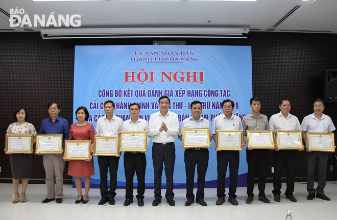 Phó Chủ tịch UBND thành phố Lê Trung Chinh (giữa) khen thưởng các tập thể đạt thành tích xuất sắc trong công tác cải cách hành chính năm 2019. Ảnh: L.P