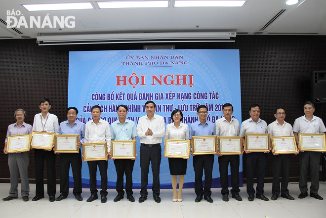 Chủ tịch UBND thành phố Lê Trung Chinh (thứ 6, trái qua) khen thưởng các tập thể đạt thành tích xuất sắc trong công tác văn thư lưu trữ năm 2019. Ảnh: L.P