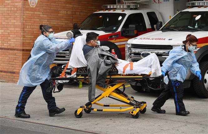  Nhân viên y tế chuyển bệnh nhân mắc COVID-19 vào một bệnh viện ở New York, Mỹ ngày 7/4/2020. Ảnh: AFP/TTXVN