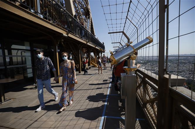  Du khách tham quan Tháp Eiffel tại thủ đô Paris, Pháp ngày 25/6/2020. Ảnh: AFP/ TTXVN
