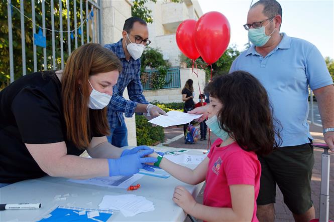  Học sinh được kiểm tra sức khỏe trước khi vào lớp tại Modiin, Israel, ngày 3/5/2020. Ảnh: THX/TTXVN