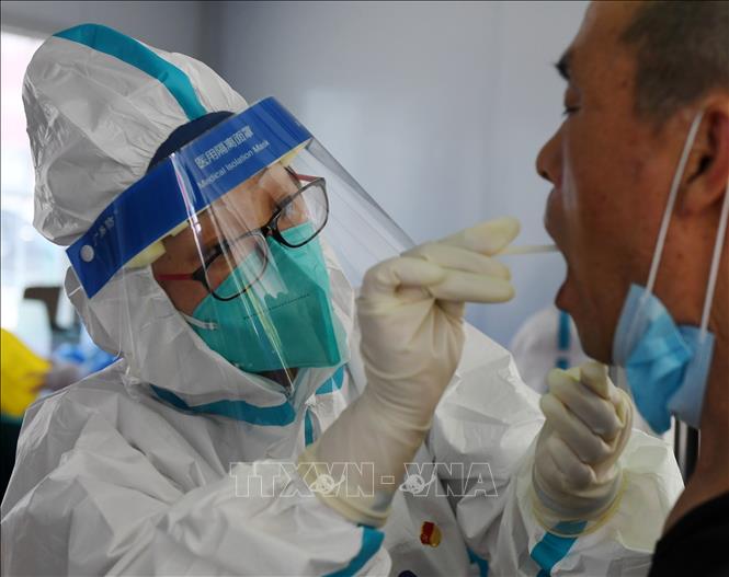 Nhân viên y tế lấy mẫu xét nghiệm COVID-19 cho người dân tại Bắc Kinh, Trung Quốc ngày 22/6. Ảnh: THX/TTXVN
