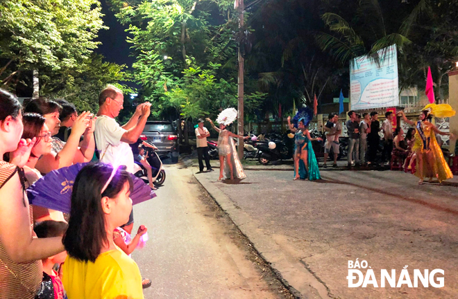 Hundreds of people enjoying jubilant atmosphere at the street carnival of live music and dancing taking place in vibrant ambience on Le Quang Dao Street