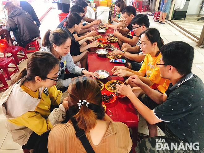 The bustling atmosphere is recorded at a crowded ‘oc hut’ selling stand