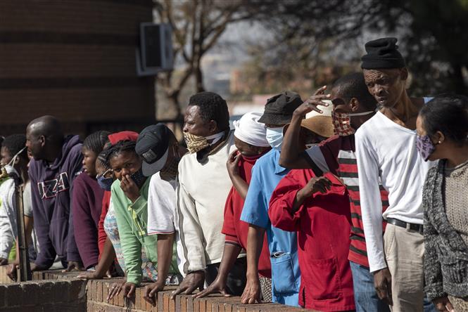  Người dân xếp hàng nhận thức ăn cứu trợ tại Johannesburg, Nam Phi ngày 5/6/2020. Ảnh: THX/TTXVN
