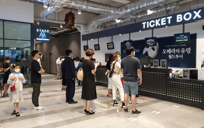 Người dân xếp hàng mua vé xem chương trình nghệ thuật “Bóng ma trong nhà hát” ở Seoul trong lúc số ca mắc Covid-19 vẫn gia tăng. Ảnh: Reuters