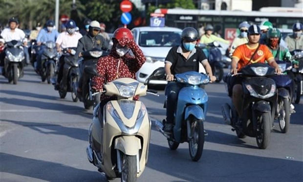 City dwellers travel on a road on a hot day in Ha Noi (Photo: VNA)