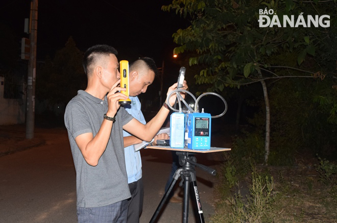 Cán bộ, nhân viên quan trắc tiến hành lấy mẫu giám sát môi trường không khí tại khu vực đường Phạm Thị Lam Anh, gần bãi rác Khánh Sơn. Ảnh: HOÀNG HIỆP