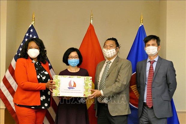 Minister Counselor at the Vietnamese Embassy in the US Hoang Thi Thanh Nga (second from left) presents the face masks to authorities in Washington D.C. (Photo: VNA)