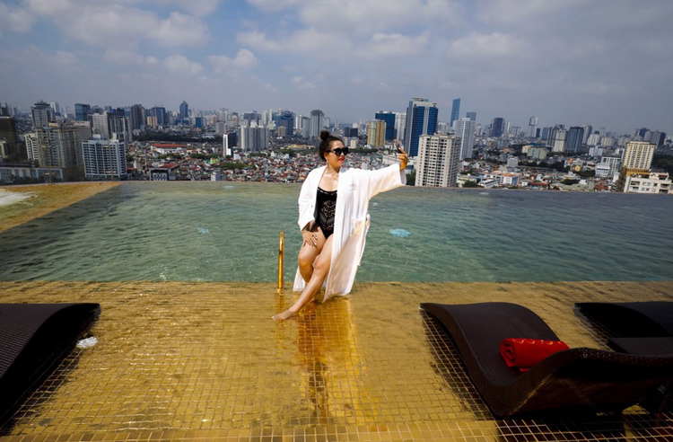 Một du khách chụp ảnh bên bể bơi vô cực tại khách sạn Dolce Hanoi Golden Lake. Ảnh: Reuters