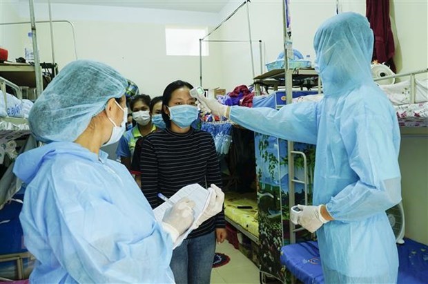 Health workers check temperature of Lao students in Vietnam (Photo: VNA)