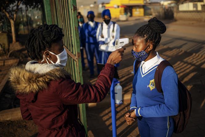  Kiểm tra thân nhiệt cho học sinh tại một trường học ở Tembisa, Ekurhuleni, Nam Phi ngày 8/6/2020 trong bối cảnh dịch COVID-19 lan rộng. Ảnh: AFP/ TTXVN