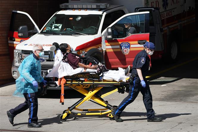  Nhân viên y tế chuyển bệnh nhân COVID-19 tới bệnh viện tại Brooklyn, New York, Mỹ, ngày 6/4/2020. Ảnh: AFP/ TTXVN