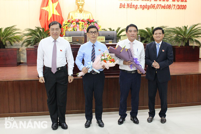 Chủ tịch HĐND thành phố Nguyễn Nho Trung (bìa phải) và Chủ tịch UBND thành phố Huỳnh Đức Thơ (bìa trái) tặng hoa cho ông Phùng Phú Phong (thứ 2, trái sang) và ông Lương Công Tuấn. Ảnh: LAM PHƯƠNG