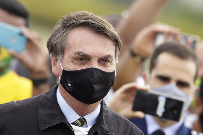 Tổng thống Jair Bolsonaro từng phản đối việc đeo khẩu trang và thực hiện giãn cách xã hội. Ảnh: AP