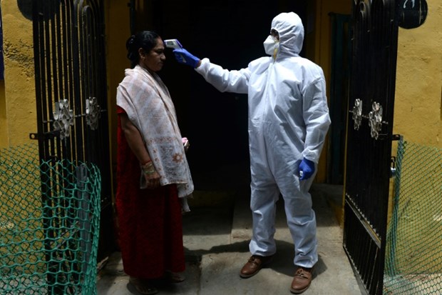 A health worker takes temperature of a resident (Photo: www.bangkokpost.com)